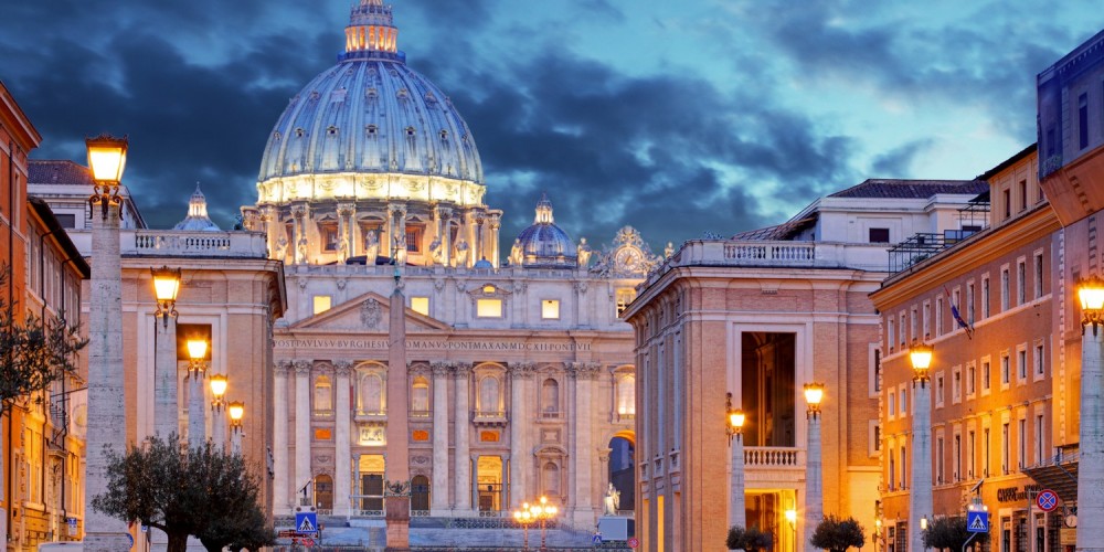 Beleuchtete Straße mit Blick auf den Petersdom in Rom bei Abenddämmerung