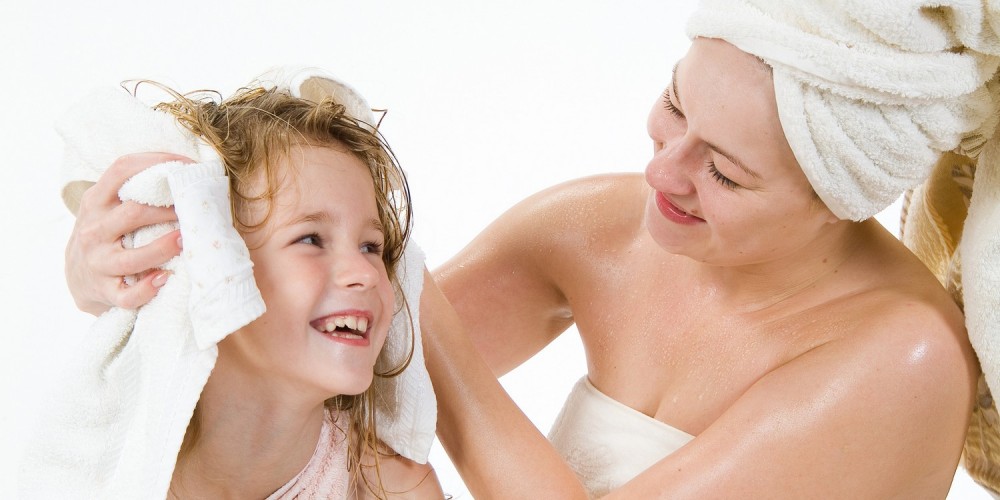 Mutter und Tochter nach Bad in Handtcher gewickelt, Mutter trocknet Tochter die Haare