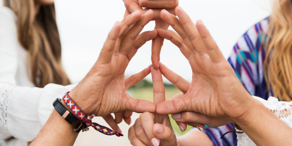 Sechs Hnde einer Gruppe junger Hippies bilden mit den Fingern ein Peace-Zeichen