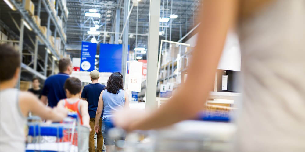 Menschen gehen mit Einkaufswagen durch ein groes Mbelhaus