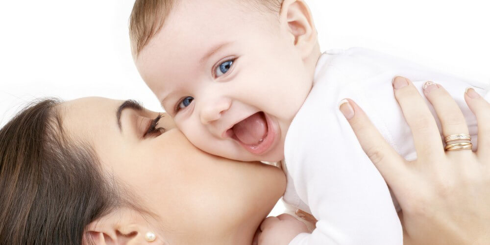 Eine Mutter hlt ihr lachendes Baby hoch