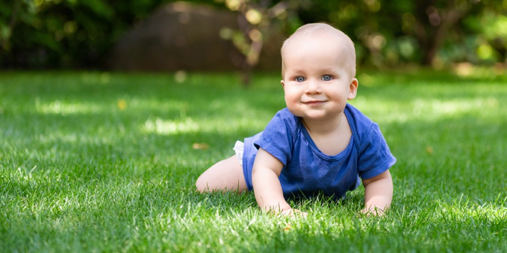 Krabbelndes Baby in blauem Strampler