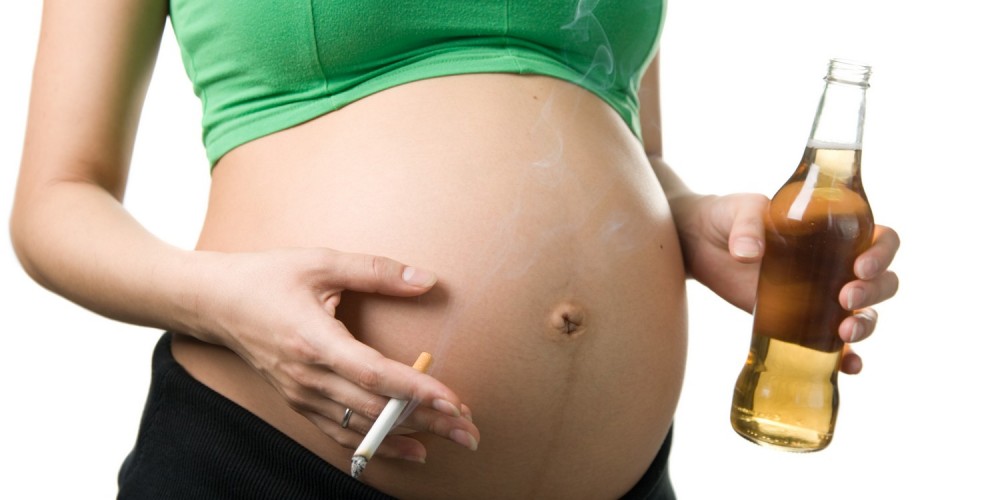 Schwangere Frau mit Zigarette und Alkohol in den Hnden