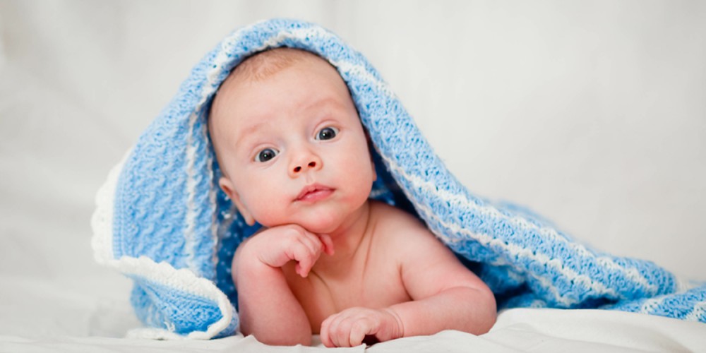 Baby unter hellblauer Wolldecke