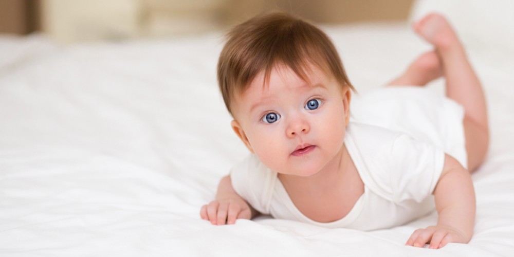 Dunkelhaariges Baby auf Bett