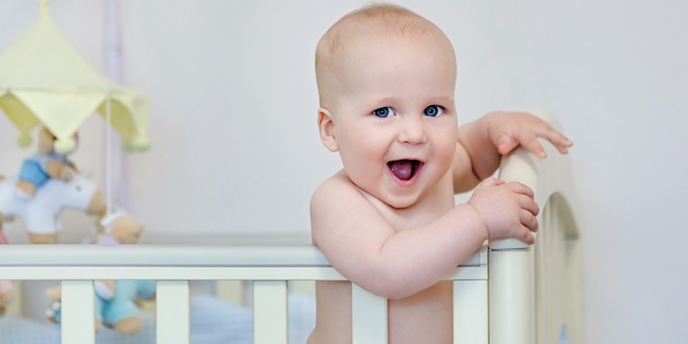 Baby steht in seinem Bett