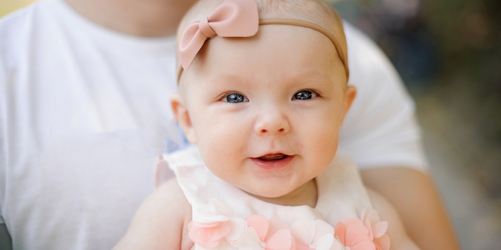 Baby mit rosa Schleife auf dem Kopf
