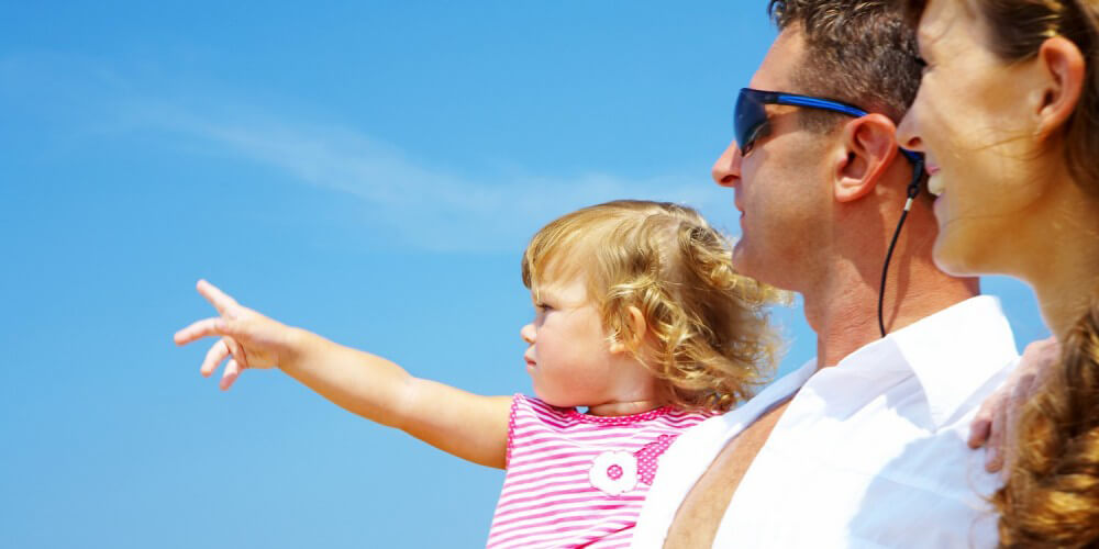 Kleines Mdchen auf den Armen ihrer Eltern