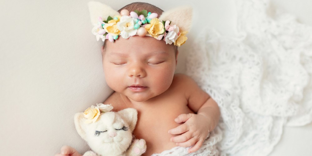 Neugeborenes mit Bltenkranz auf dem Kopf
