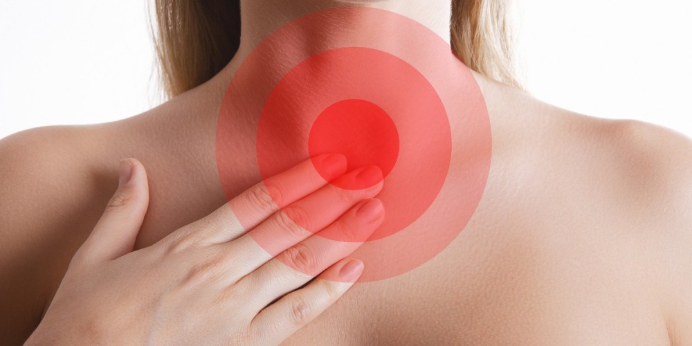 Frau fasst sich an den Halsbereich, rote Kreismarkierungen in Hhe der Luft-/Speiserhre