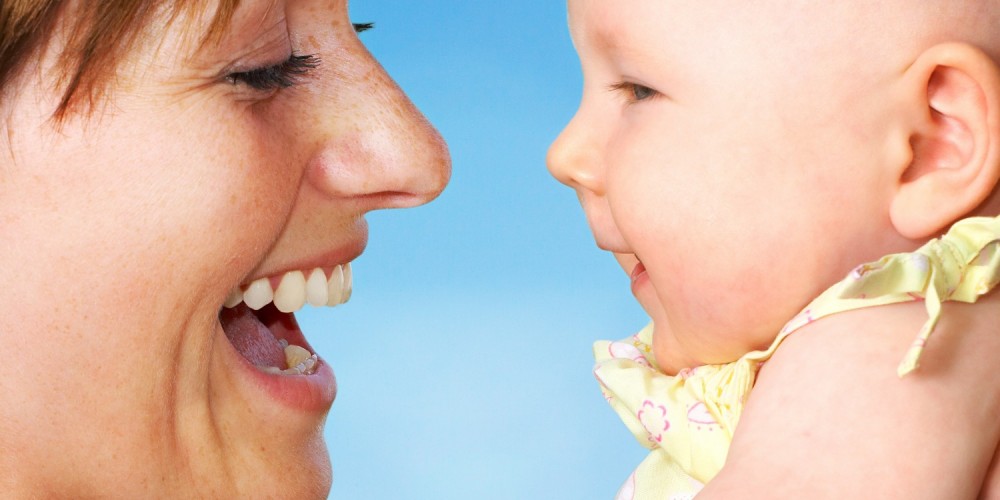 Lachende Mutter h�lt ihr Baby hoch