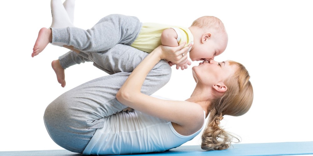 Mutter und Baby bei Fitnessbungen auf einer blauen Yogamatte